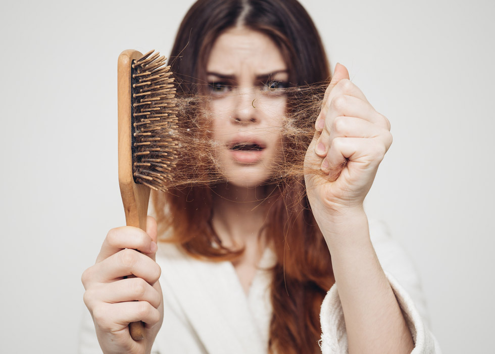 Une femme perd beaucoup de cheveux en se brossant les dents.